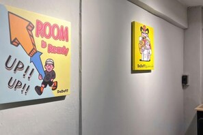 Two wall-mounted posters with cartoon characters and text. - DaDa97 Hostel (Bangkok)