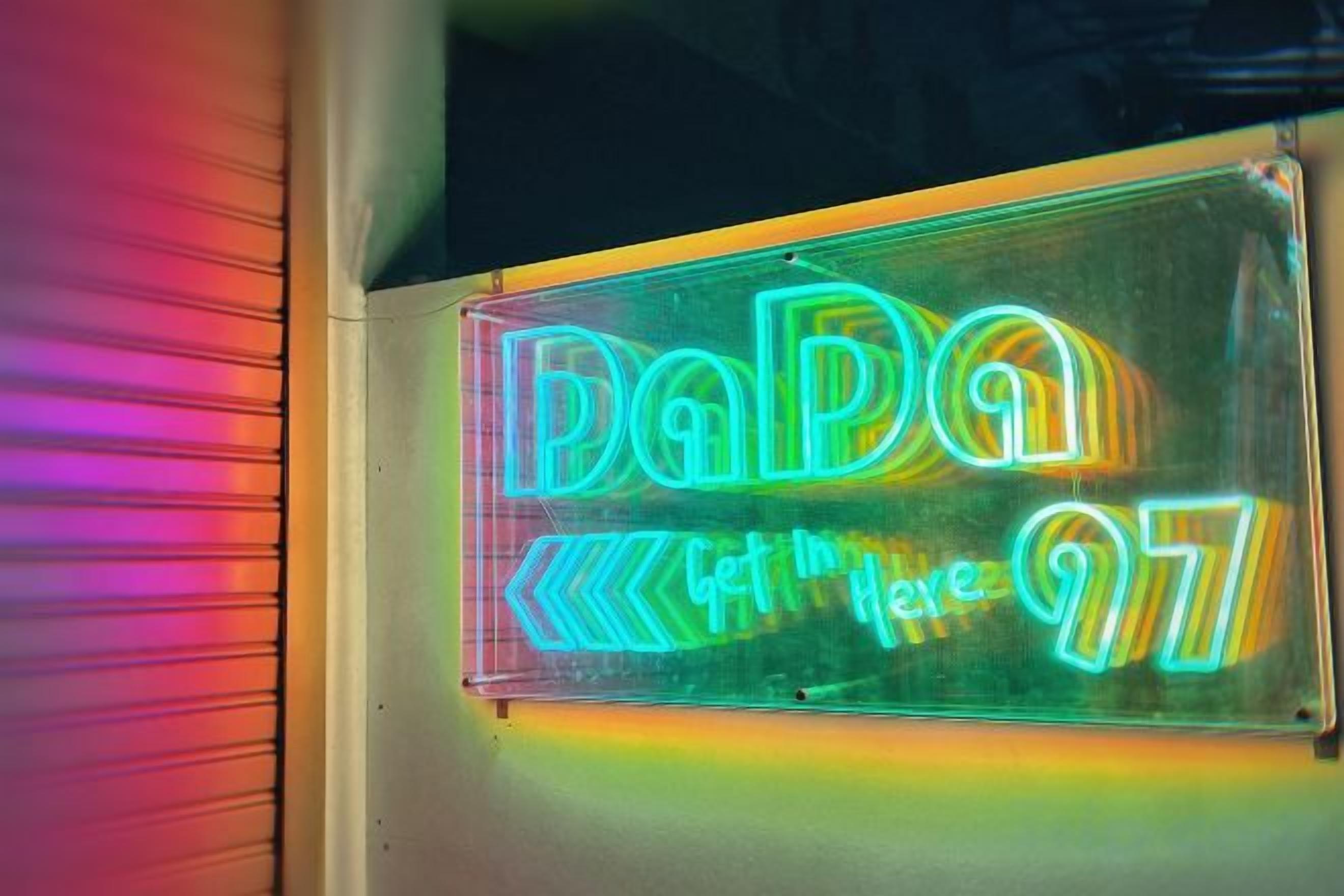 A neon sign with the text 'DaPa' and arrows pointing left and right.