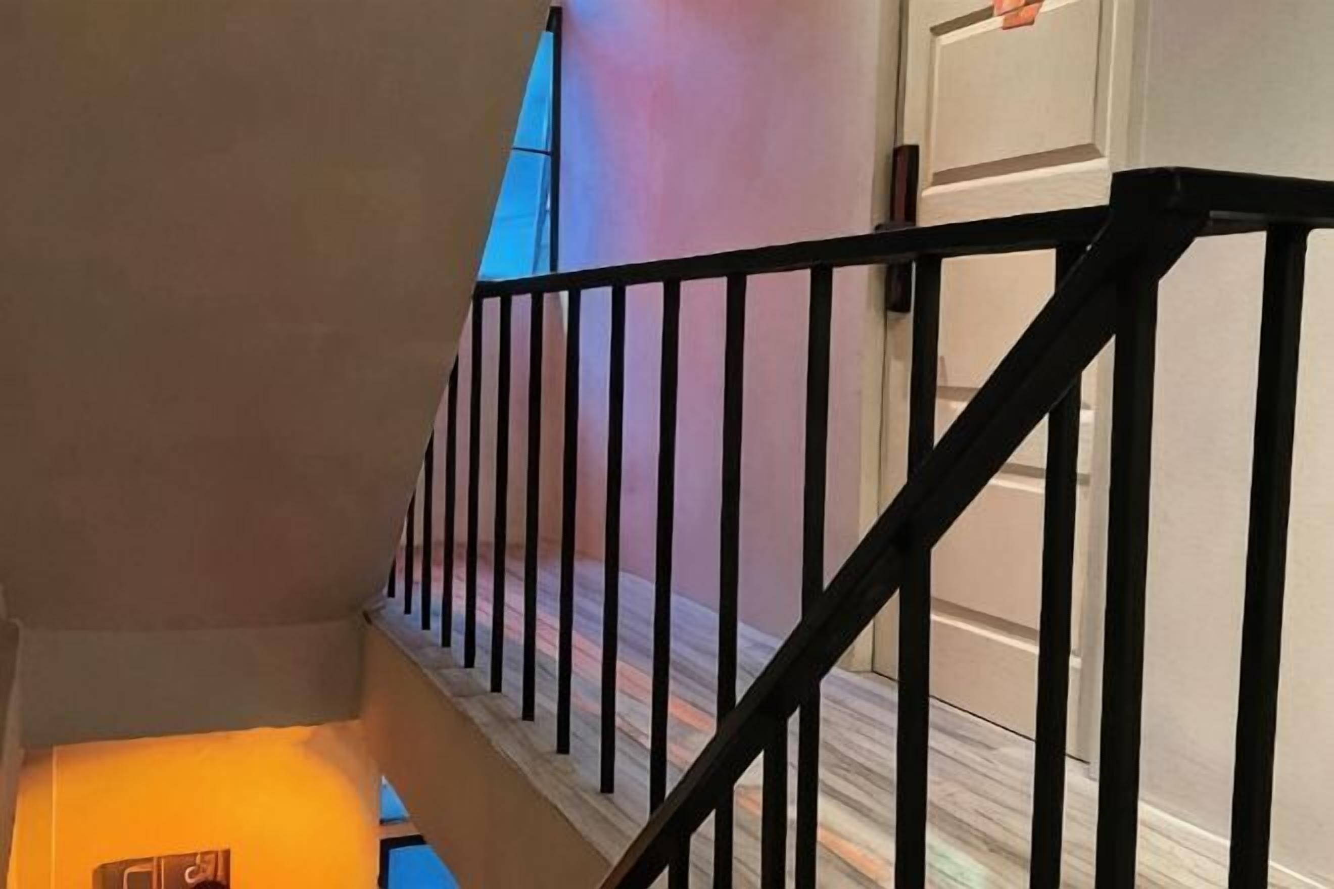 Un escalier avec des rampes noires et un plancher en bois.