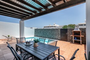A patio with a table, chairs, a barbecue, and a pool. - Holiday Villa 'Vera' with Mountain Views, Private Pool, and Wi-Fi (Playa Blanca)