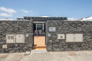 A stone wall entrance to Villa Vera, with a door leading to an interior space. - Holiday Villa 'Vera' with Mountain Views, Private Pool, and Wi-Fi (Playa Blanca)