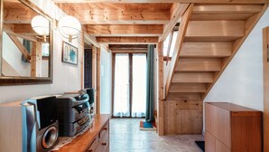 A wooden interior with a staircase, a mirror, and a wooden cabinet. - Two-room apartment in the valleys of Capriasca (Ca' del Primo) (Odogno)