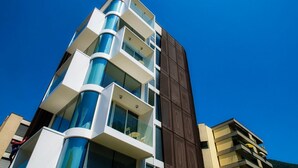 A multi-story building with balconies, large windows, and a clear blue sky. - A one-bedroom apartment for an excellent stay (FLAT IRON 7) (Viganello)