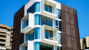 Un edificio moderno con un diseño arquitectónico único, que cuenta con varios balcones y ventanas amplias.
