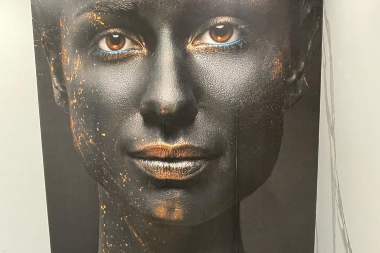 Un dettaglio di una scultura con una superficie scura e strutturata, impreziosita da tocchi dorati.