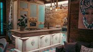 A kitchen with a central island, a stone wall, and a rustic ceiling. - THE STONE DIMORA - Madonie Suite & Garden SPA-Exclusive Villa & Private Park  (Blufi)