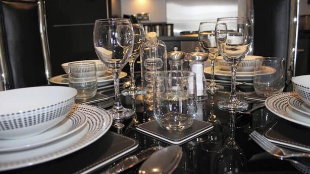 A table set with multiple wine glasses, plates, and cutlery. - Central 2-bedroom flat with private parking in Aberdeen (Aberdeen)