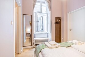 A bedroom with a bed, a window, a radiator, a wardrobe, and a mirror. - Stylish Aparthotel | 1 Room+Lounge by Mariahilfer (Vienna)