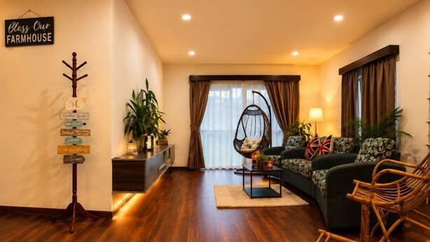 Una sala de estar acogedora con un sofá, una mecedora, una mesita de centro y una planta.