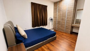 A bedroom with a bed, a bedside table, a standing fan, and a wardrobe. - Cameron Farm House (Ulu Telom)