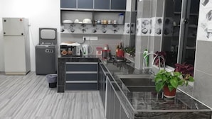 Una cucina moderna con mobili grigi, un piano di lavoro in marmo e un lavello.
