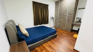 Una camera da letto con un letto, un comodino, una ventola e un armadio.