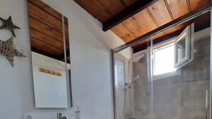 A modern bathroom with a wooden vanity, a white toilet, a glass shower enclosure, and a large mirror. - Apartment 'Casa Deco' with Mountain Views, Wi-Fi and Air Conditioning (Los Llanos)