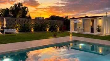Una piscina con vista a un edificio y un área verde.