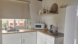 A kitchen with white cabinets, a microwave, a sink, and a refrigerator. - Apartment 'Casa Deco' with Mountain Views, Wi-Fi and Air Conditioning (Los Llanos)