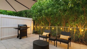 An outdoor patio with a grill, wicker furniture, and string lights. - 1/1 Relaxing Retreat in Sunny Bonita Springs (Bonita Springs)