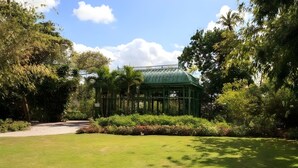A conservatory with a green roof, surrounded by lush greenery and a well-maintained lawn. - 1/1 Relaxing Retreat in Sunny Bonita Springs (Bonita Springs)