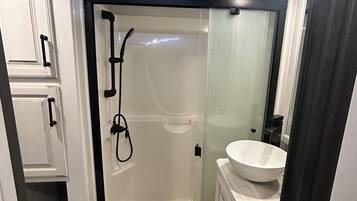 Een douche, handdoeken, zeep, toiletpapier