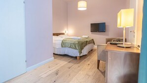 A bedroom with a bed, bedside table, lamp, TV, and a desk with a chair. - Modern Room with Private Bath | Mariahilferstraße (Vienna)