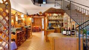 Een rustiek interieur met een houten bar, een trap en een eethoek.