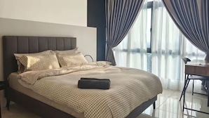 Quarto com cama, cortinas, escrivaninha e vista.