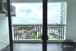A balcony with a metal railing, a window, and a view of a cityscape. - 8 Scape New Big Pool Homestay ByStay (Johor Bahru)