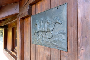 Una pared de madera con una placa de metal que muestra un caballo.