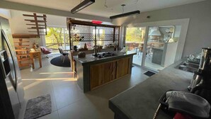 Een moderne keuken met een centraal eiland, ingebouwde apparatuur en een eetgedeelte met uitzicht.