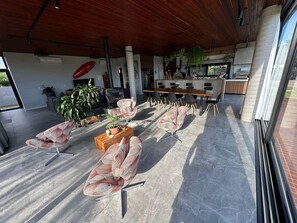 Tilava sisätila, jossa on modernit istuimet, keittiö sekä suuret ikkunat, joista pääsee runsaasti luonnonvaloa.