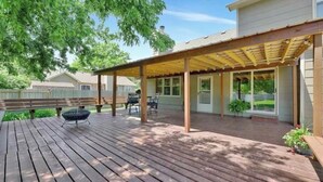 A covered patio with wooden flooring, outdoor furniture, and a pergola structure. - Backyard bliss/firepit/spacious/cozy/centrally located (Wichita)