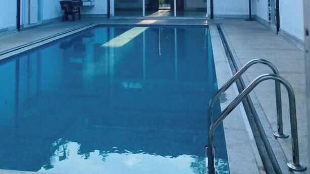 Piscina com vista ampla da área ao redor, incluindo um alpendre coberto e uma porta que dá para outra área.