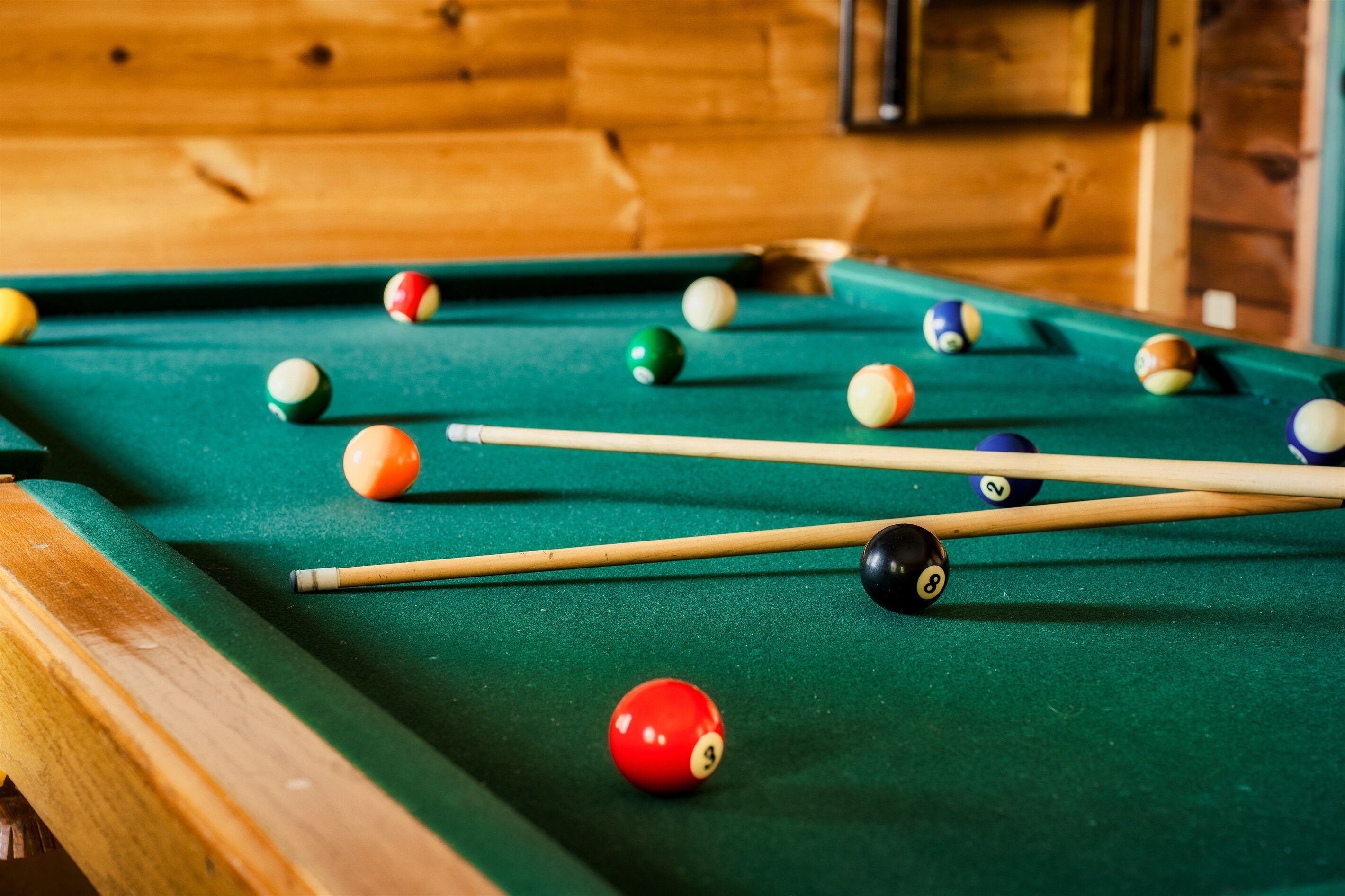 A pool table with balls and cues.