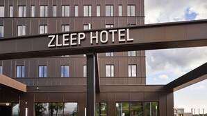 A sign for the ZLEEP HOTEL with a modern building in the background. - Four Points Flex by Sheraton Lyngby (Lyngby-Taarbaek Municipality)