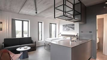 A modern interior with a sofa, a dining table, a kitchen island, and a large window.