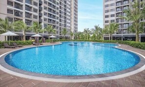 Ein Pool, umgeben von Palmen und modernen Gebäuden.