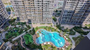 A high-rise residential building with multiple balconies, a central swimming pool, and landscaped gardens. - Beautiful Hotel at Vinhomes Grand Park (Ho Chi Minh City)