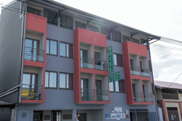 A hotel with a modern facade, balconies, and a sign indicating it is located in Amazonas Du Fleuve. - Amazonia de Saint-Laurent (Saint Laurent du Maroni)