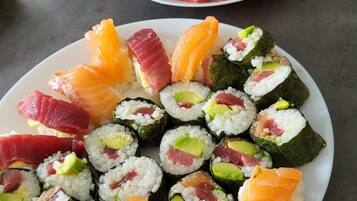 Two plates of sushi with various toppings, including salmon and avocado, on a table.