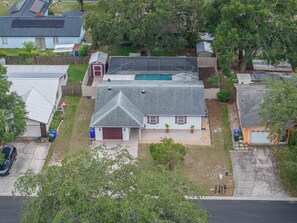 A residential property with a large house, a swimming pool, and a fenced backyard.