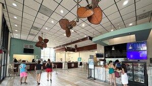 Een ruime lobby met een hoge plafond, meerdere zithoeken, een Starbucks balie en een koeltoog.