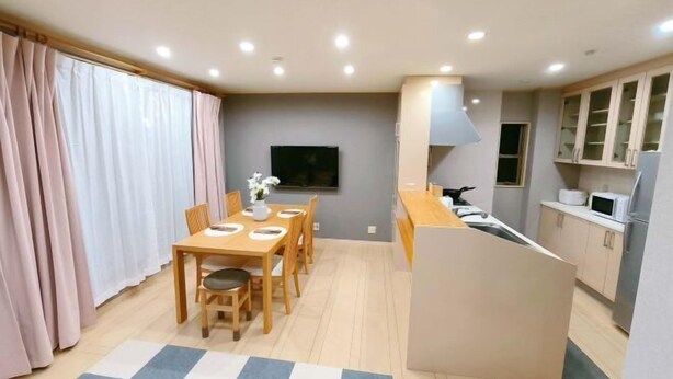 A modern kitchen with a microwave, stove, and cabinets. - Xiao Ban Yaju (Osaka)