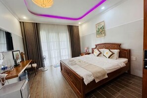 Una habitación de hotel con cama, escritorio y televisor.