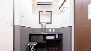 A compact bathroom with a small sink, a mirror, a towel rack, and a stool. - HOTEL GRAND FORT (Tokyo)