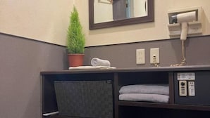 A bathroom with a mirror, a hairdryer, a potted plant, and towels. - HOTEL GRAND FORT (Tokyo)