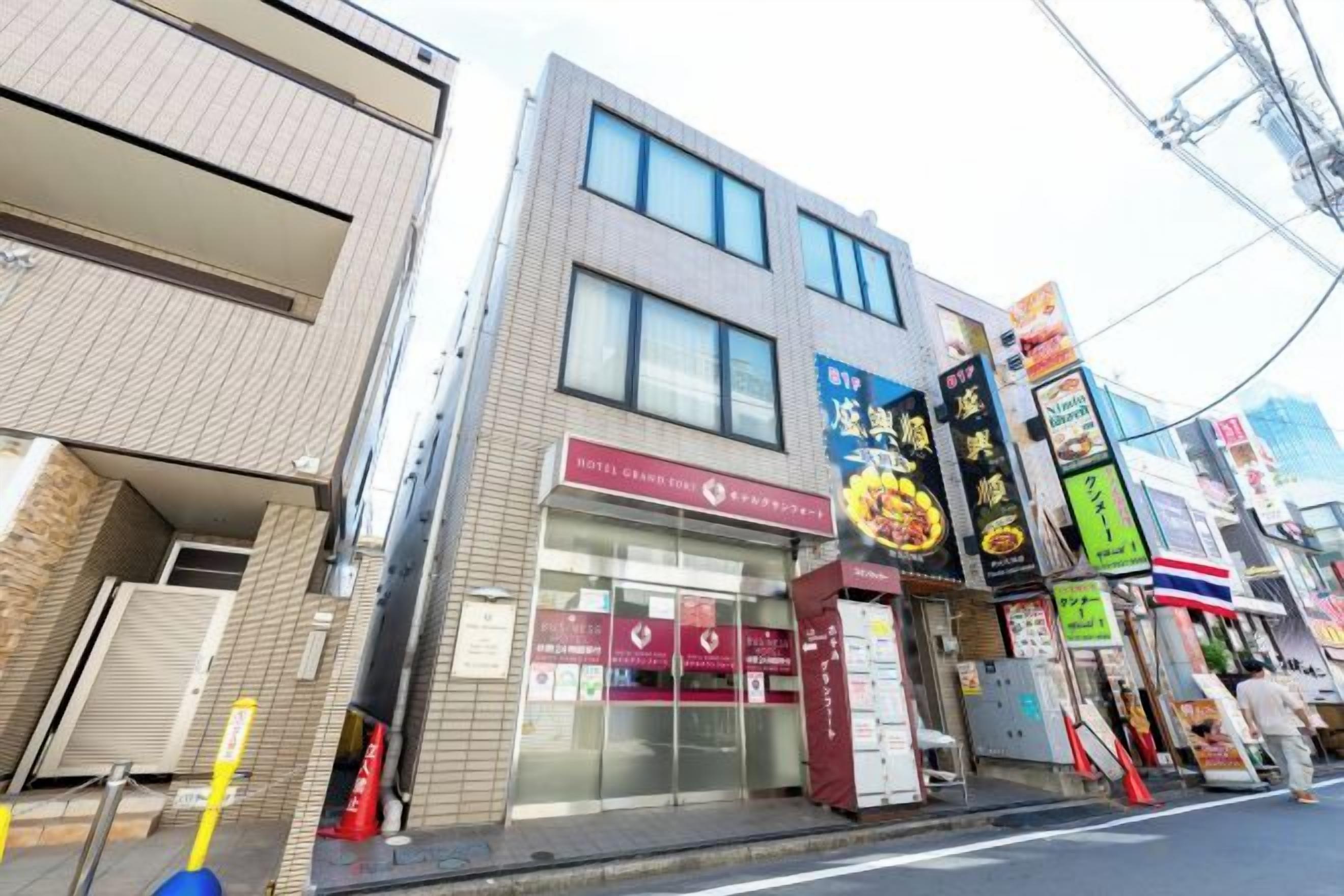 A commercial building with multiple storefronts, including a restaurant with a prominent sign.
