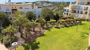 Un quartiere residenziale con edifici moderni, un prato curato e diversi alberi.