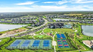 Asuinalue, jossa on taloja, suuri rakennus ja urheilukeskus, jossa on tenniskenttiä.