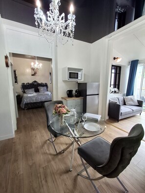 Un espace de vie moderne comprenant un coin repas, une kitchenette, une chambre et un coin salon.