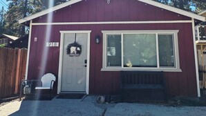 A maroon building with a white door, a window, and a mailbox.