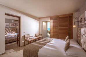 Un dormitorio con cama, escritorio, sillas, armario de madera y balcón.